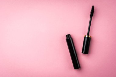 Mascara pembe arka planda. Kirpik makyaj için temel ürünler.