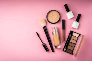 Pembe arka planda profesyonel kozmetik ürünleri.