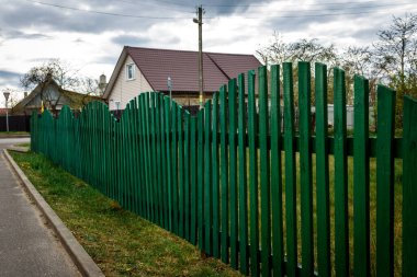 Şehrin asfalt yolunun yakınındaki ahşap çit..