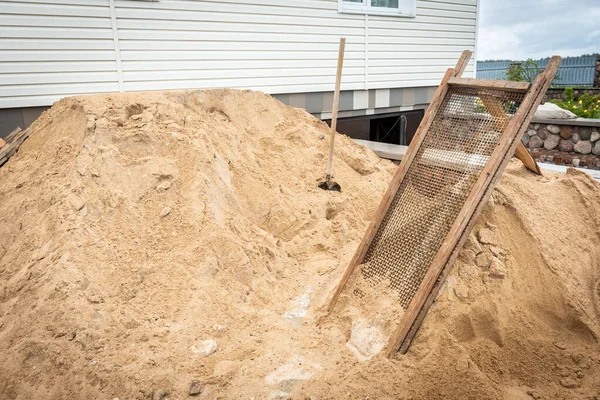 İnşaat alanındaki bir ızgaraya kum yerleştirmek.