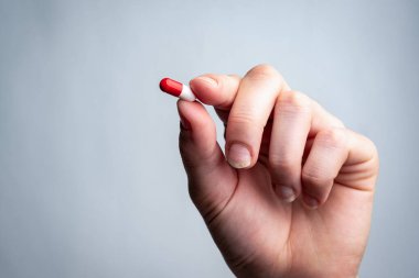 Elinde hap tutan koruyucu maskeli bir kız. Coronavirus, Covid-19.