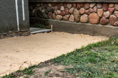 Asfalt döşemek için zemini kumla döşemek.