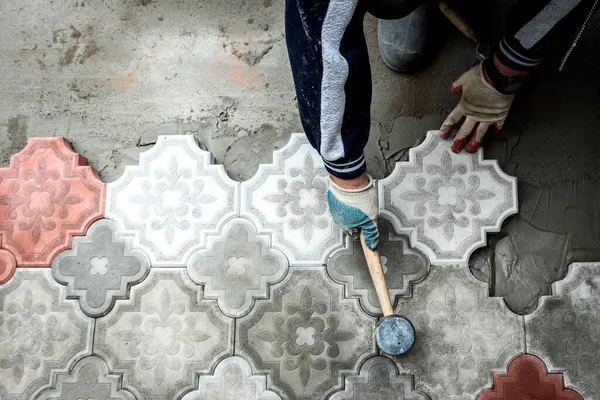 Man hitting the concrete slab with a rubber hammer.