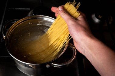 Mutfaktaki ocakta tavada haşlanmış spagetti..