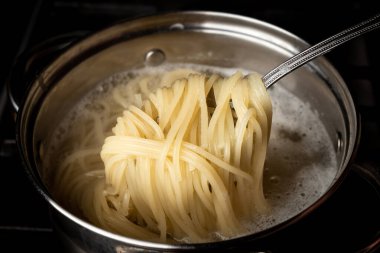 Mutfaktaki ocakta tavada haşlanmış spagetti..