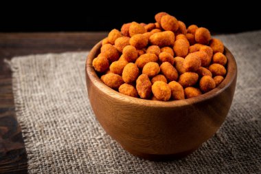 Koyu ahşap arka planda kavrulmuş Paprika fıstığı. Lezzetli çerez.