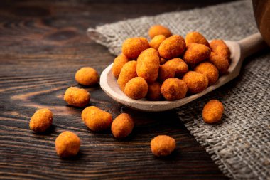 Koyu ahşap arka planda kavrulmuş Paprika fıstığı. Lezzetli çerez.