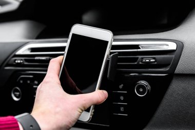 Modern akıllı telefon aygıtı araç gösterge panelindeki telefon tutucusuna monte edildi.