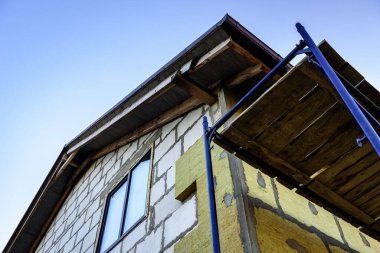 Mineral yünündeki fiberglasları güçlendirmek için yalıtımlı duvara yapıştırıcı katmanı sürüyorum..