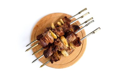 Beyaz arka planda izole edilmiş ahşap kesme tahtasındaki domuz şiş kebap şişleri..