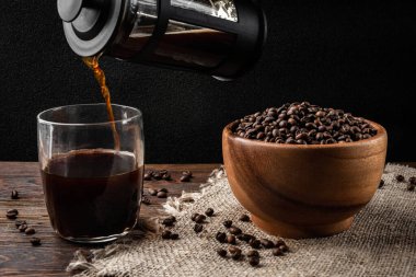 Koyu arkaplandaki fincana Fransız presinden kahve döküyorum..