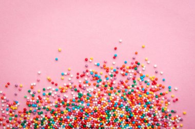 Pembe arka planda renkli serpintiler.