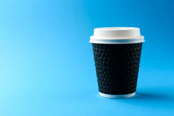 Coffee paper cup on blue background.