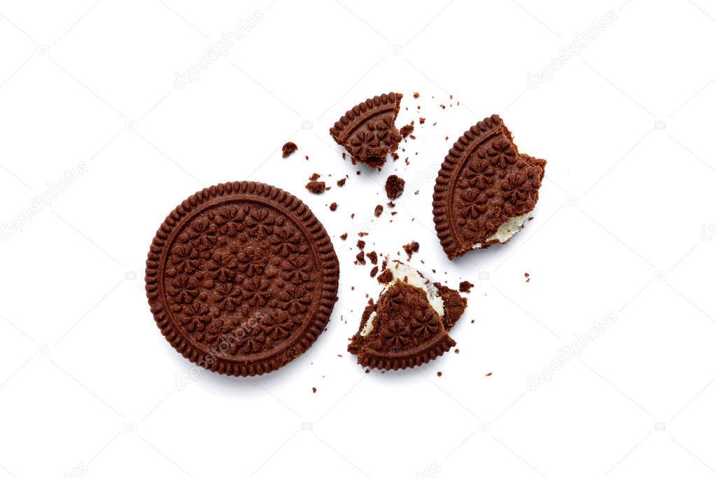 Broken chocolate cookies with milk filling isolated on white background. Top view.