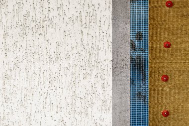 The texture of the multi-layered facade of the building. Mineral wool, facade grid, plaster and decorative plaster. 
