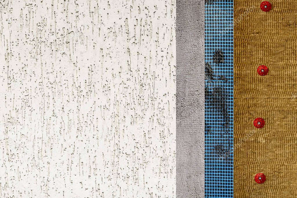 The texture of the multi-layered facade of the building. Mineral wool, facade grid, plaster and decorative plaster. 