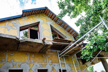Mineral yünündeki fiberglasları güçlendirmek için yalıtımlı duvara yapıştırıcı katmanı sürüyorum..