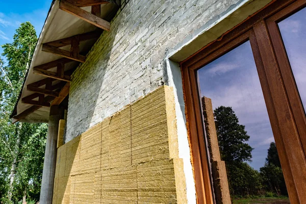 Thermal insulation of a building on a construction site with mineral wool sheets. 