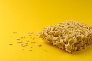 Dry instant noodles on yellow background.