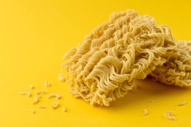 Dry instant noodles on yellow background.