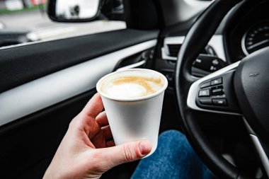 Direksiyonun arkasında kağıt kahve fincanı var.