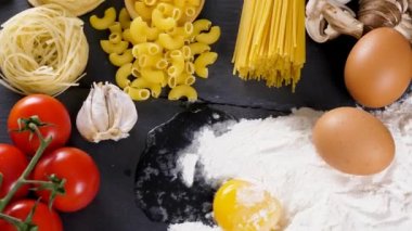 Masanın üzerinde farklı türde makarna var.