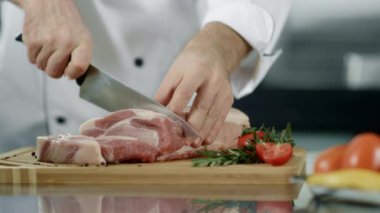 Şef yemek pişirmek için eti keser.