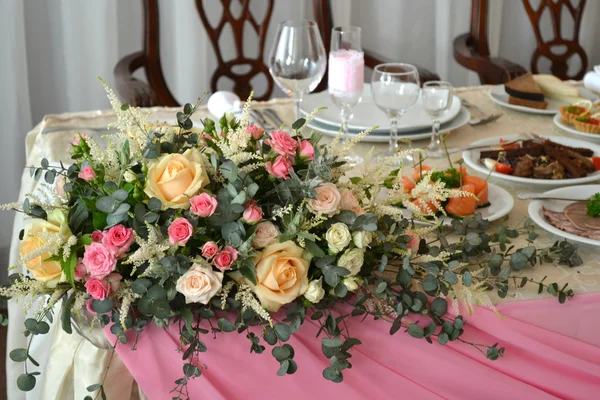 Um buquê de rosas na esquina da mesa de casamento — Fotografia de Stock