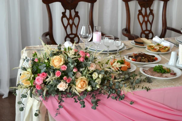 Букет роз на углу свадебного стола — стоковое фото