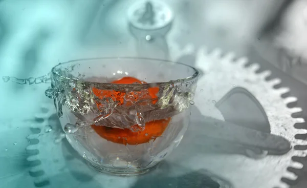 Pomarańczowy owoc spada i przelewanie do wody incolor. Pojęcie czasu — Zdjęcie stockowe