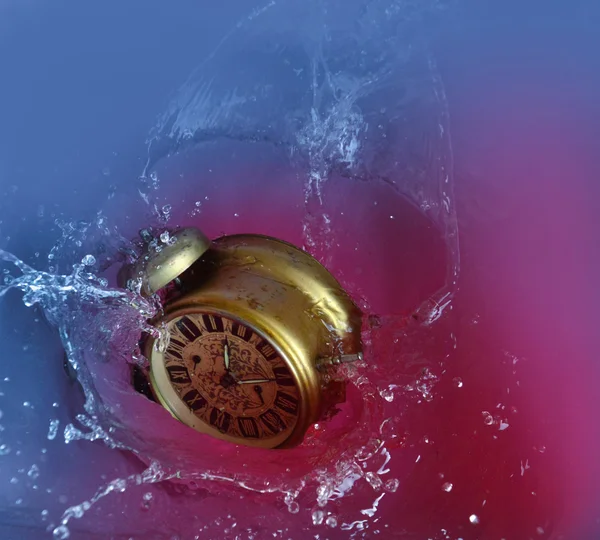 Vintage alarm clock is falling and splashing into water.    Concept of time — Stock Photo, Image