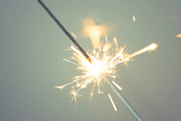 Sparkler gri bir arkaplanda yanıyor. 