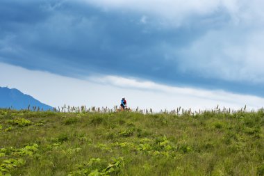  Dağın tepesinde, bulutlu gökyüzünün altında.