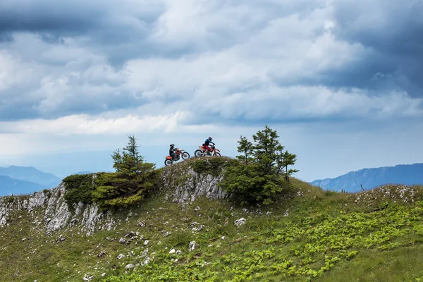 Zwei Motocross Fahrer Auf Dem Gipfel Des Berges Unter Wolkenverhangenem — Stockfoto