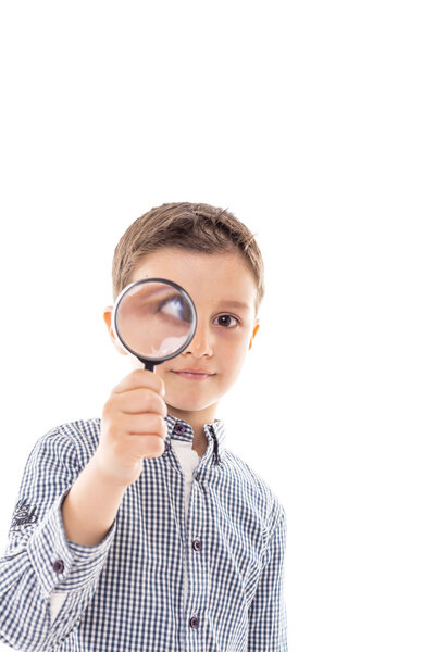 Closeup of a beautiful child looking through a magnifying glass loop over white background