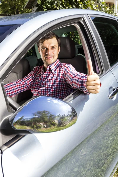 Χαρούμενος νεαρός άνδρας, με τον αντίχειρα επάνω στο τιμόνι — Φωτογραφία Αρχείου