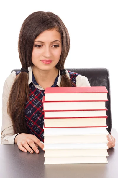 Portret van een schoolmeisje op zoek naar een stack van boeken — Stockfoto