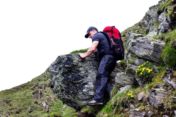 Young man hiking on difficult mountain trail — Stock Photo, Image