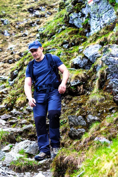 Young man hiking into the mountains — Stock Photo, Image