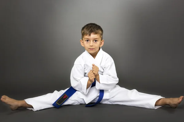 Chłopiec w kimono szkolenia na podłodze — Zdjęcie stockowe