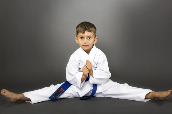 Adorable chico en kimono entrenando en el suelo — Foto de Stock