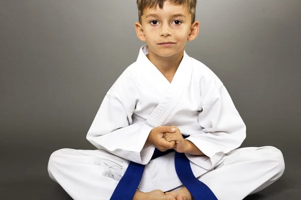 Portrait of a boy in kimono training on the floor — Stock Photo, Image