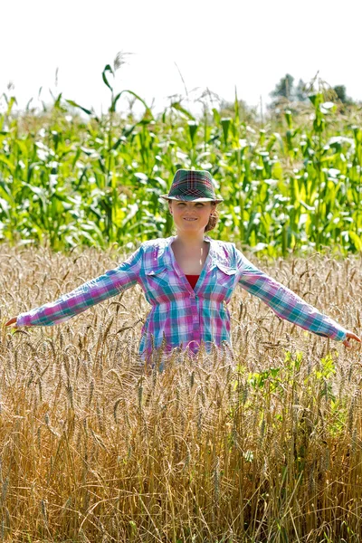 Young woman standing in a wheat field — Stock Photo, Image