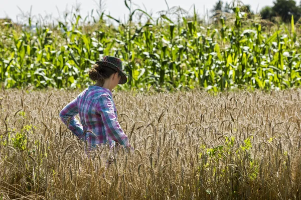 Young woman standing in a wheat field — Stock Photo, Image