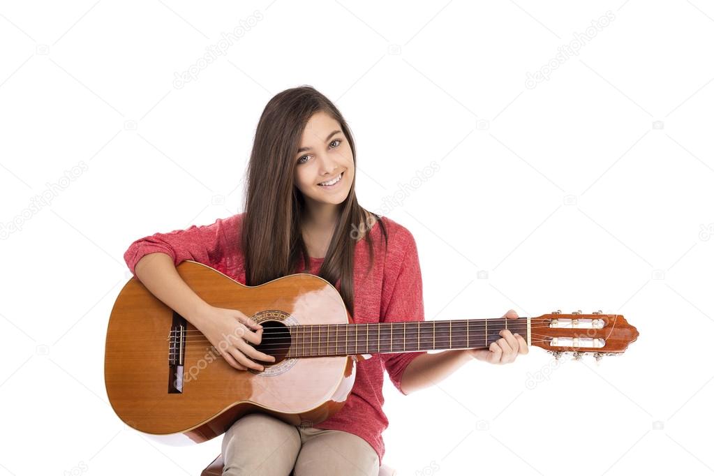 Pretty teenage girl playing an acoustic guitar