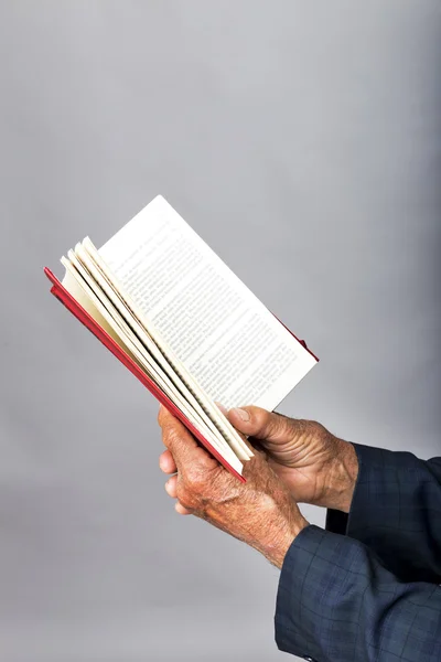 Nahaufnahme eines alten Mannes, der ein offenes Buch hält — Stockfoto