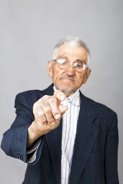 Senior man holding a pill ready to take some medicine — Stock Photo, Image