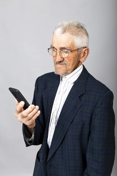 Portrét starého muže pomocí mobilní telefon — Stock fotografie