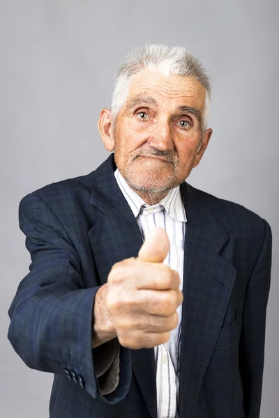 Detailní portrét starší muž ukazuje palec — Stock fotografie