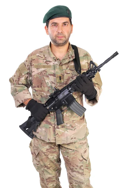Portrait of young man in army clothes holding a weapon — Stock Photo, Image